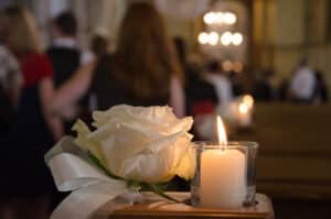 White rose and candle in church for a funeral